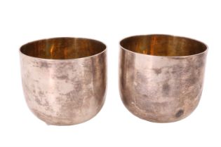 A pair of George II silver beakers, of plain cylindrical form and gilt lined, differing sponsor's