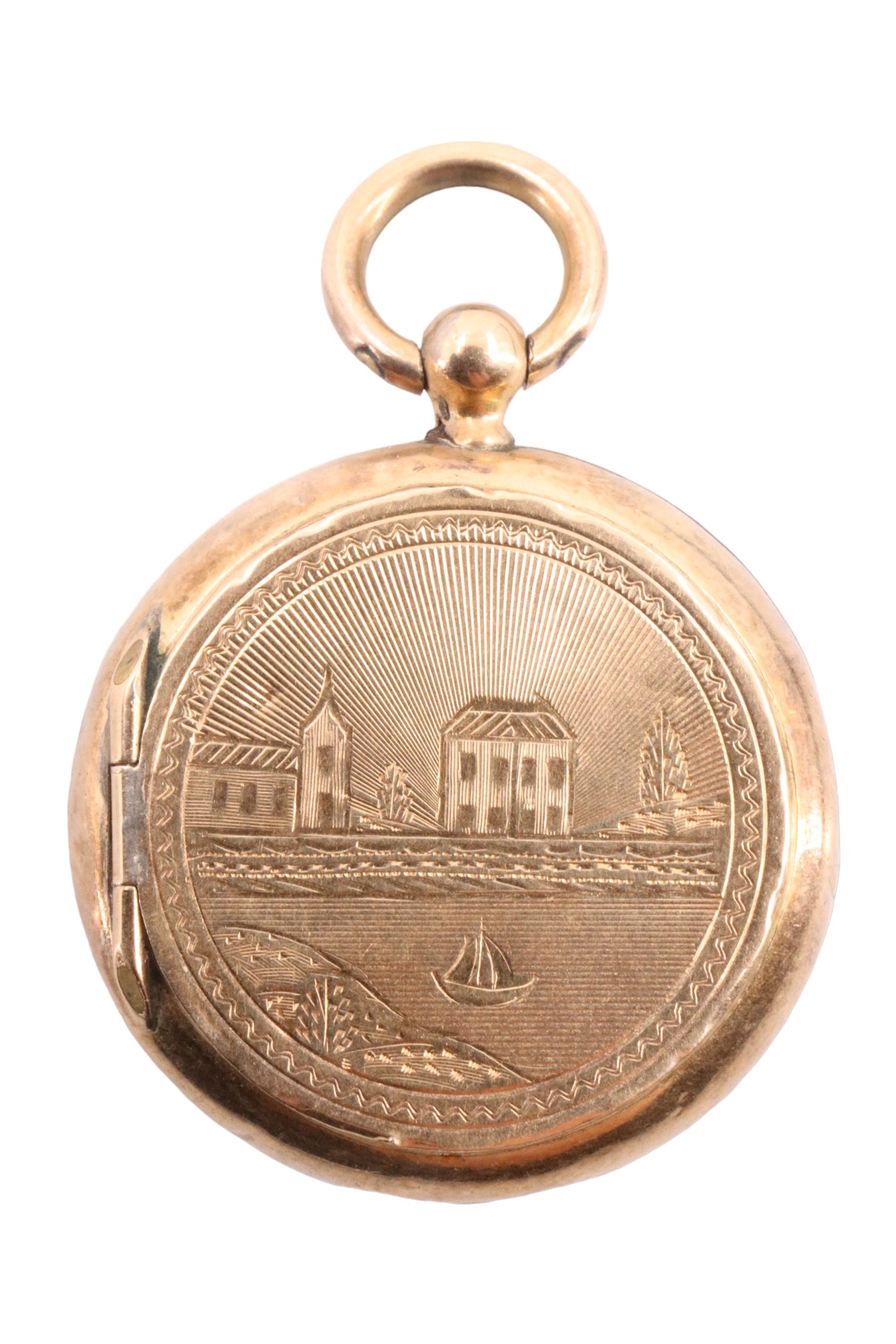 A vintage French gold triple locket, the front engraved with a church and house on a river