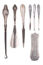 A group of silver-handled dressing / grooming tools, including a shoehorn, a button hook, nail