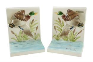 A pair of hand-painted ceramic bookends modelled as birds in flight, 15.5 cm high