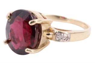 A contemporary rhodolite and diamond finger ring, having a 4.7 carat oval garnet prong set between