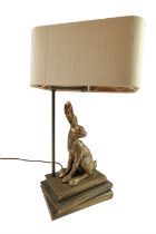 A late 20th Century bronzed resin table lamp modelled as a hare sitting on books, 50 cm