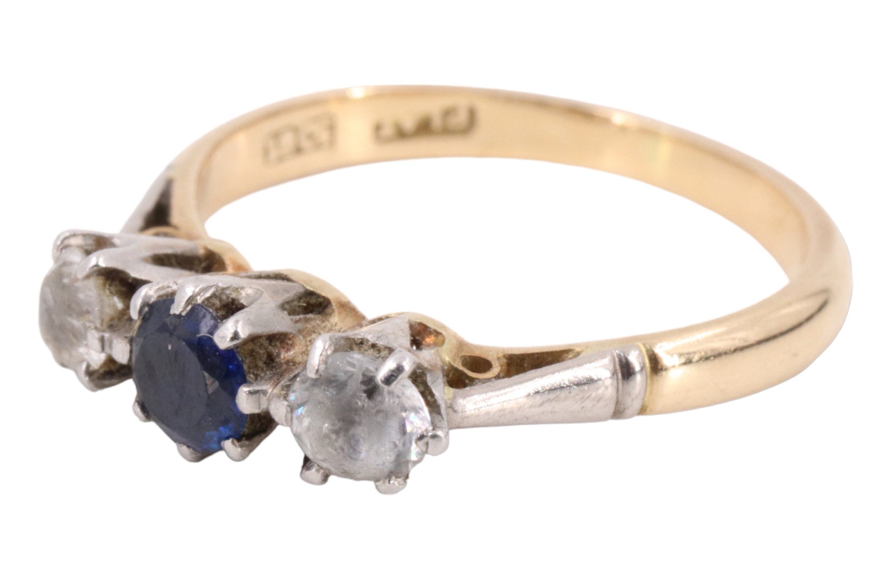 A sapphire and spinel three stone finger ring, having a 4 mm blue sapphire between two white