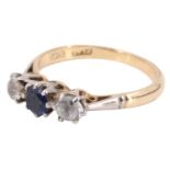 A sapphire and spinel three stone finger ring, having a 4 mm blue sapphire between two white