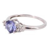 A contemporary tanzanite and diamond finger ring, having a central brilliant of 1.9 carats between