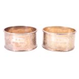 A pair of cased Chinese white metal napkin rings, variously engraved with a phoenix and a dragon,