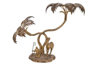 An early 20th Century gilt brass figure of an Arab and camel under a palm tree, 37 cm x 29 cm
