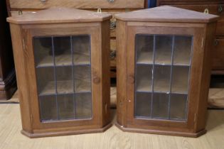 A pair of diminutive leaded glazed oak hanging corner cabinets by Derek 'Lizardman' Slater of Crayke