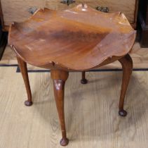 A mid 20th Century flame figured mahogany coffee table, having a dished cusped top on cabriole legs,