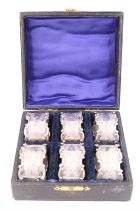 A cased set of six Edwardian silver napkin rings, each bearing applied alternating C-scrolls,