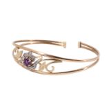 A contemporary amethyst and white stone set floral bangle, having a 5 mm amethyst brilliant