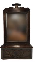 A late 19th / early 20th Century carved oak hall mirror having a lidded brush box, 54 x 28 cm