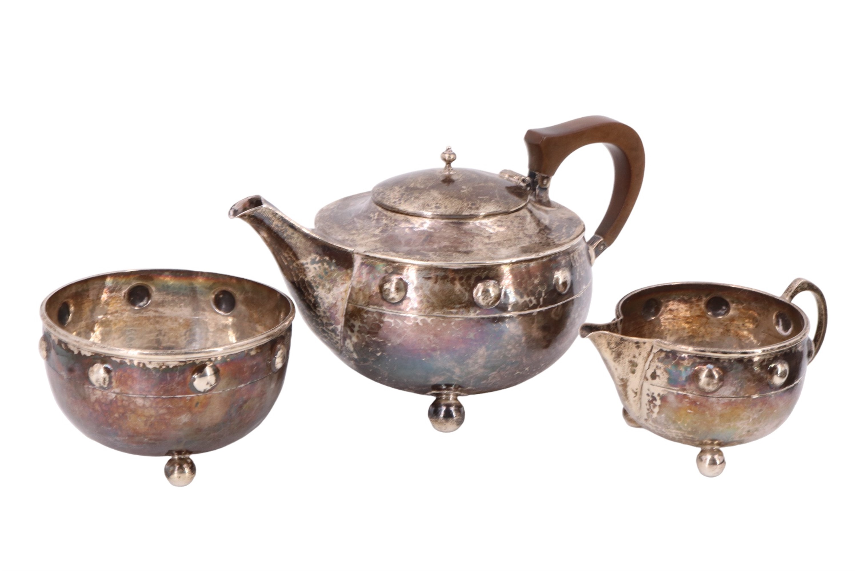 An Arts and Crafts silver bachelor tea set, of shouldered ovoid form and having a planished finish