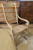 A traditional rush seated spindle back rocking armchair, 108 cm