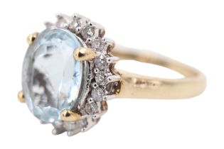 A contemporary aquamarine and diamond dress ring, having a 2.5 carat oval set above 18 surrounding