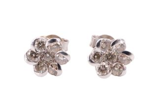 A pair of diamond daisy set stud earrings, each having a central brilliant surrounded by six further