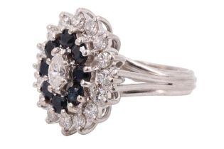 An impressing sapphire and diamond oval cluster ring, comprising a central marquise cut diamond
