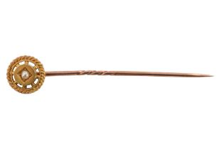 A cased early 20th Century seed pearl set stick pin, the central roundel surrounded by a cabled