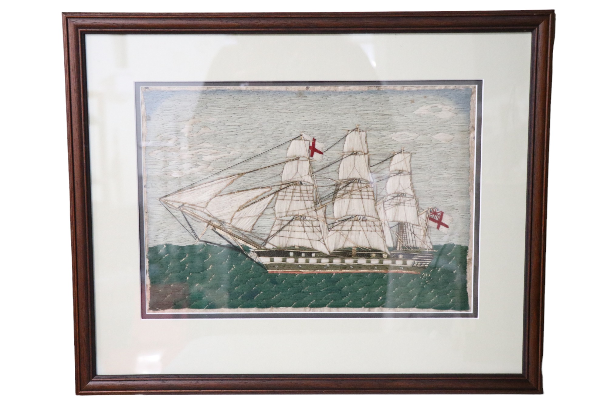 A 19th Century wool- and silk-work picture of a Royal Navy Man-o-War frigate, in later double card