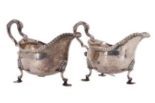 A pair of George III silver sauce boats, each having a gadrooned rim, a closed compound scroll