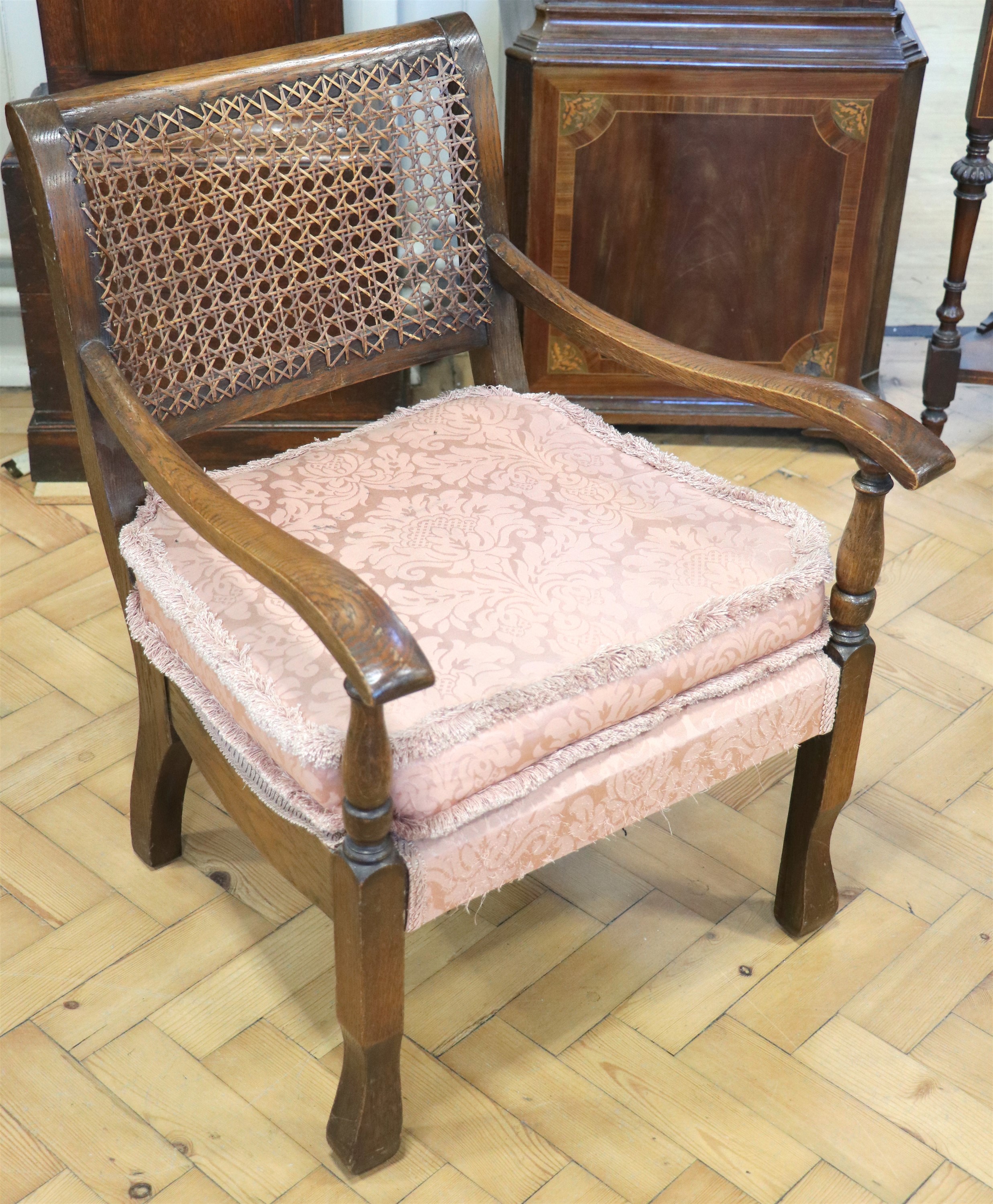 A 1930s cane backed oak boudoir armchair, 71 cm