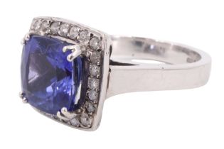 A contemporary tanzanite and diamond dress ring, having a 4 carat cushion cut set above 24