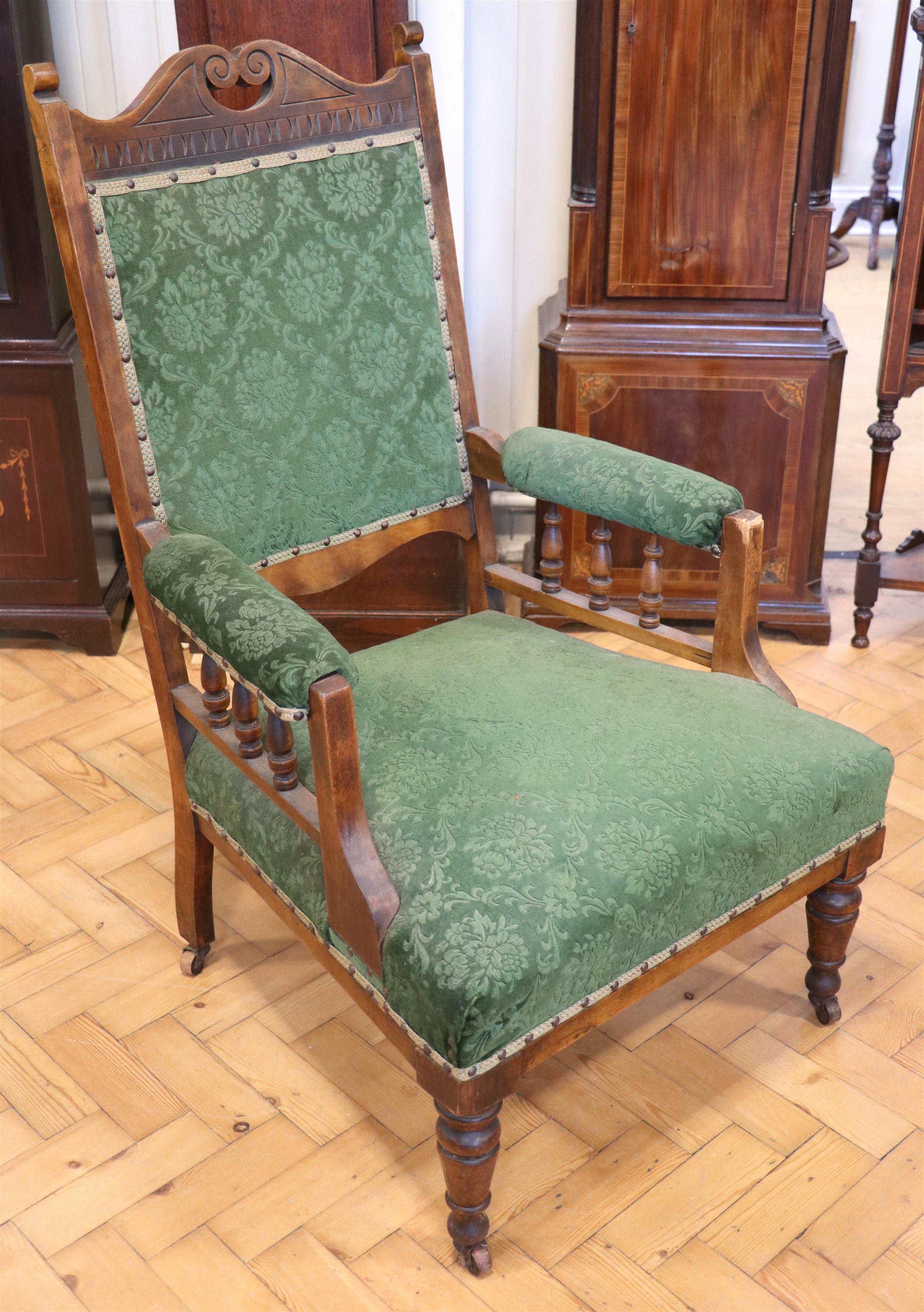 A Victorian upholstered and carved open-arm lounge chair