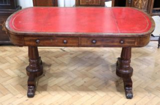 A Georgian mahogany writing table, having a rounded oblong top with a gilt tooled red leather