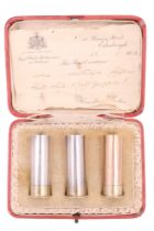 A cased set of three Scottish silver novelty pepperettes, in the form of 12 bore shotgun cartridges,