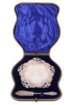 An Edwardian cased silver butter set, comprising a silver dish with everted planar rim, edged with