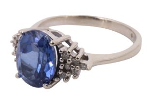 A contemporary sapphire and diamond dress ring, having a 2 carat oval flanked by adorsed sloping
