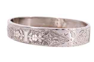 A Victorian silver bangle, decorated with profusely engraved flora and foliage, Birmingham, 1886, 60