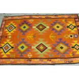 Kelim rug with polychrome all-over geometric design on an orange ground, 286cms x 178cms, together
