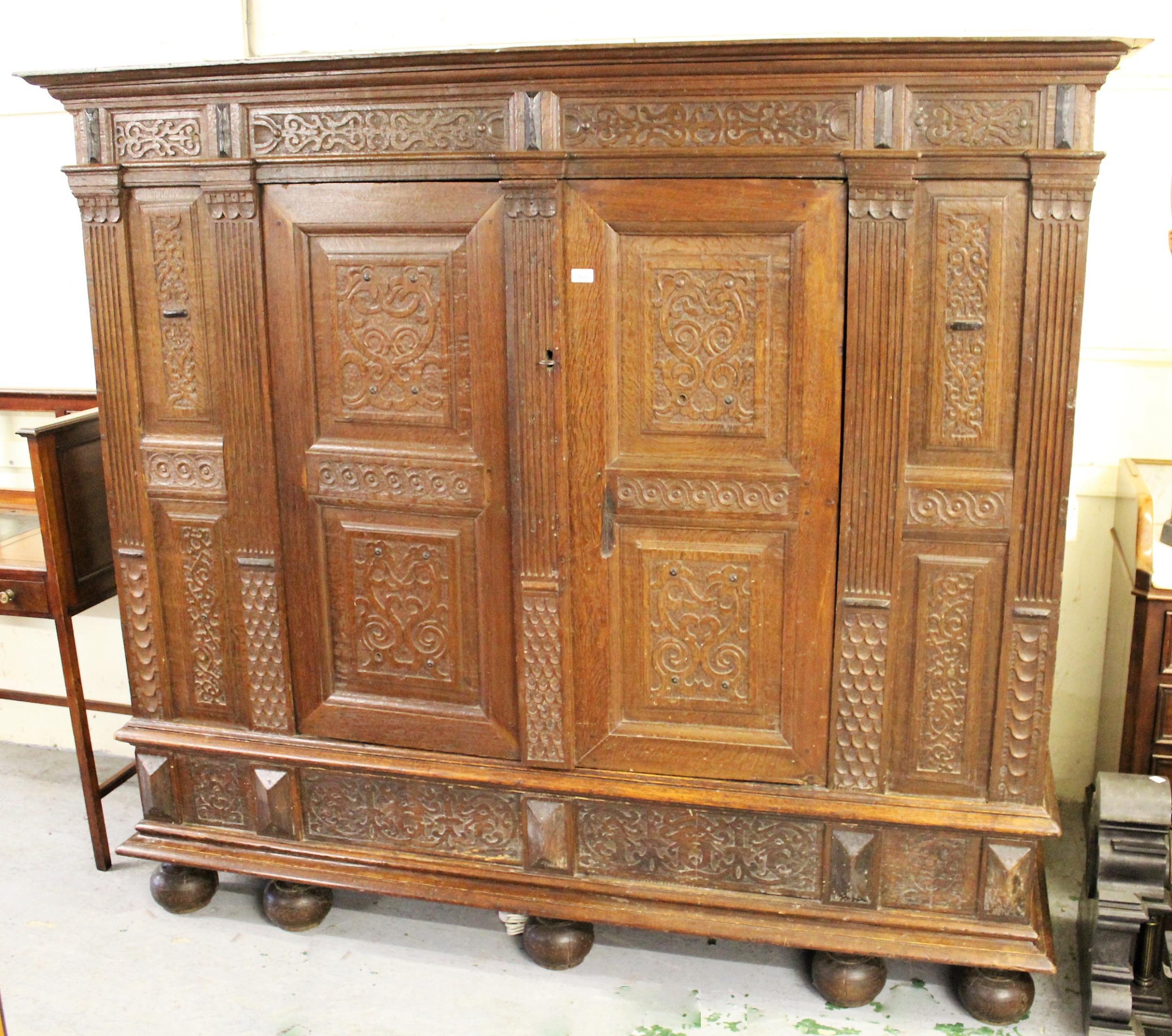 Continental oak armoire, the moulded cornice above a pair of carved fielded panelled doors flanked