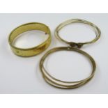 Two yellow metal bangles, 24g, together with a rolled gold bangle