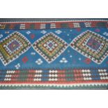 Kelim rug with a triple medallion design on pale blue ground with borders, 213cms x 137cms