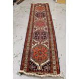 Indo Persian runner with five medallion design on an ivory ground with borders, 300cms x 70cms