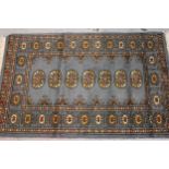Small Pakistan Bokhara rug with a single row of gols on a blue ground, 125cms x 80cms, together with