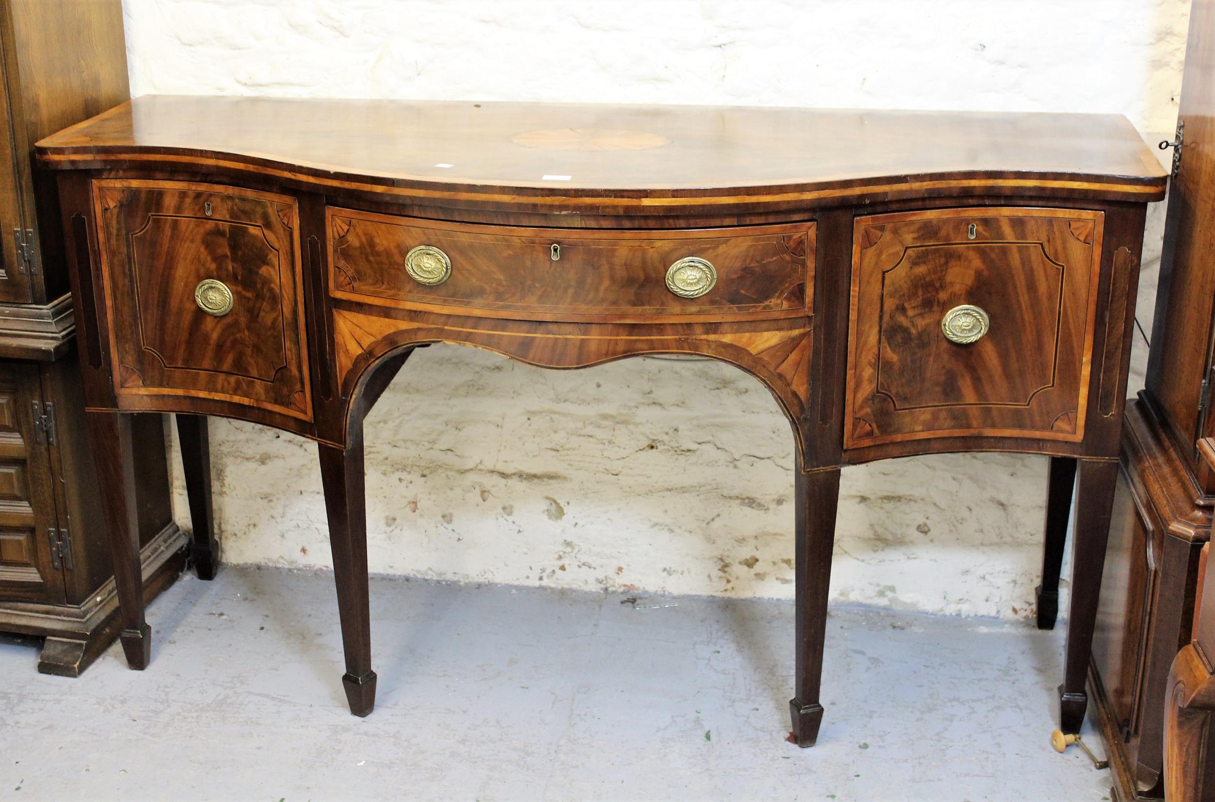 George III mahogany crossbanded and line inlaid serpentine fronted sideboard, with an arrangement of