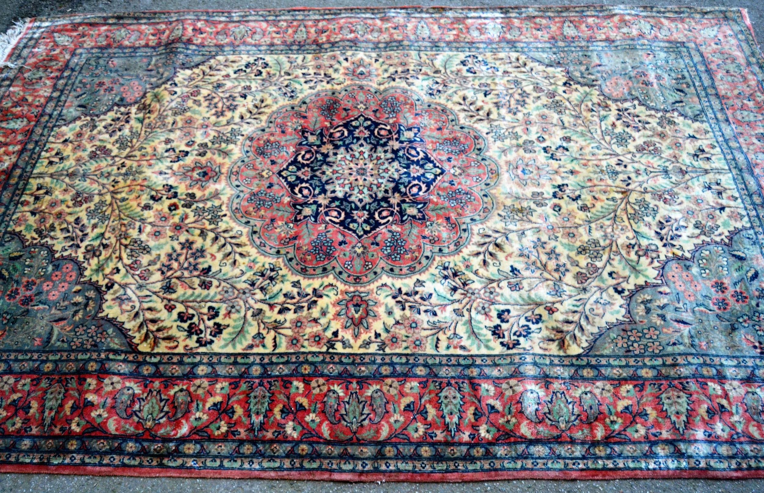 Indo Persian rug with a medallion and all-over stylised floral design in shades of deep blue, pink