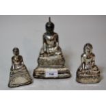 Graduated set of three oriental white metal covered altar candlesticks, each in the form of a seated