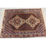 Sirjan rug with a twin medallion and all-over Boteh design on a dark ground with borders and