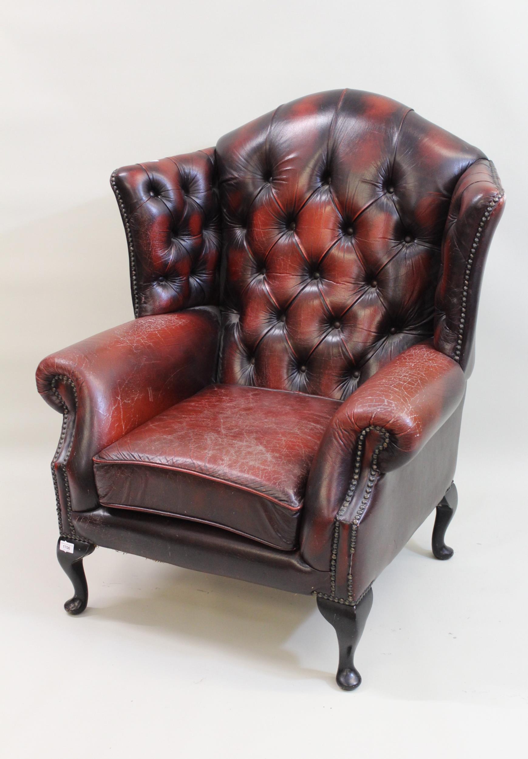 Mid 20th Century red buttoned leather upholstered wing armchair, on cabriole supports