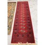 Machine woven runner of Turkoman design, 2.7m x 70cms approximately, together with a similar,