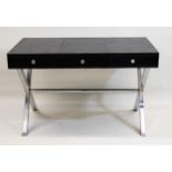 Andrew Martin, a simulated black alligator leather and chrome three drawer writing desk, on