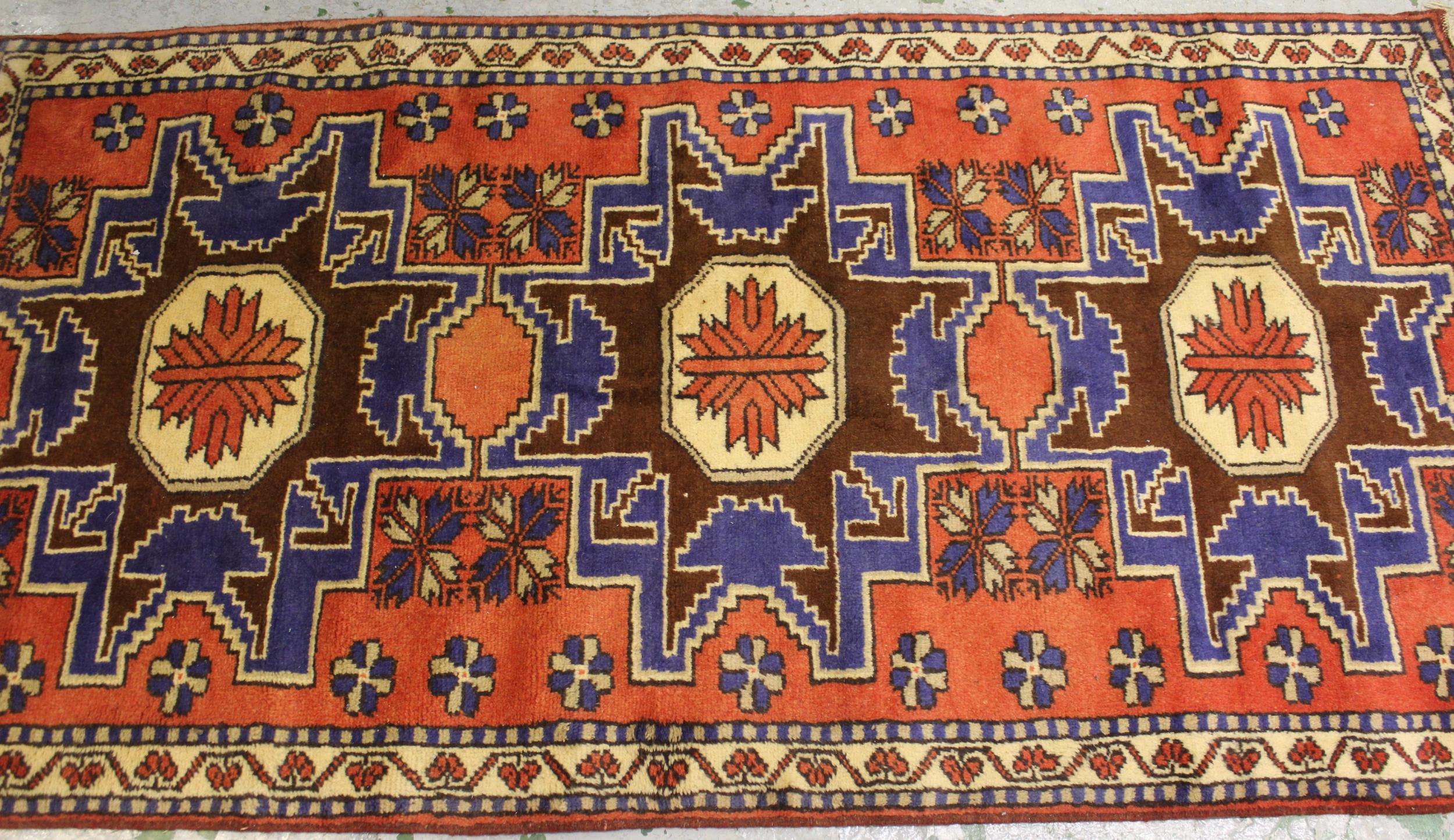 Small modern Turkish rug with a triple medallion design in shades of red and blue, 196cms x 103cms