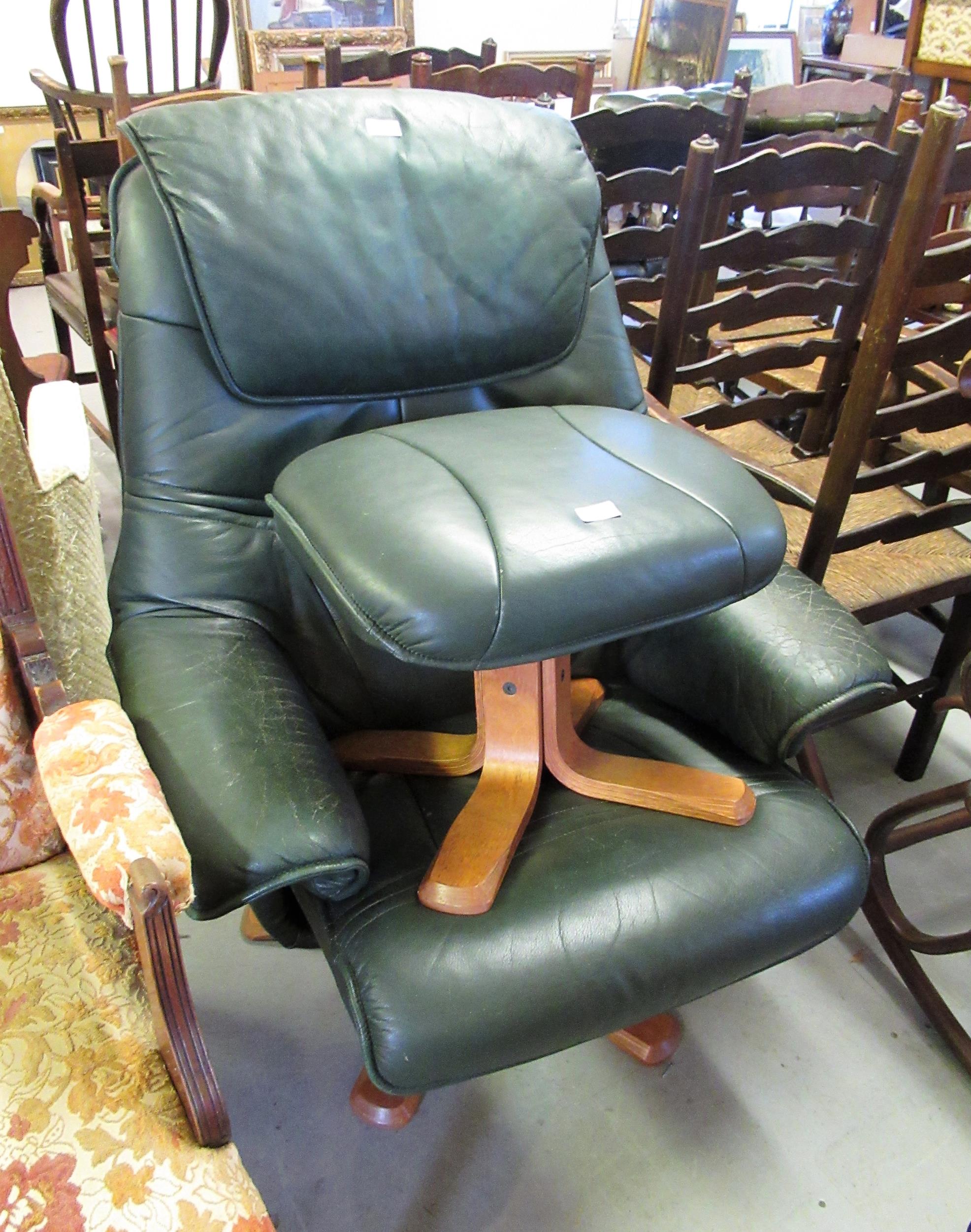 Modern green leather upholstered recliner chair with matching stool