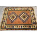 Small Turkish rug with a twin hooked medallion design on a rose ground with borders, 132cms x 108cms