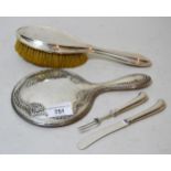 Embossed silver backed dressing table mirror, a silver backed brush and two silver handled pistol