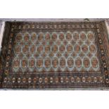 Pakistan rug of Turkoman design with three rows of gols on a green ground with borders, 187cms x